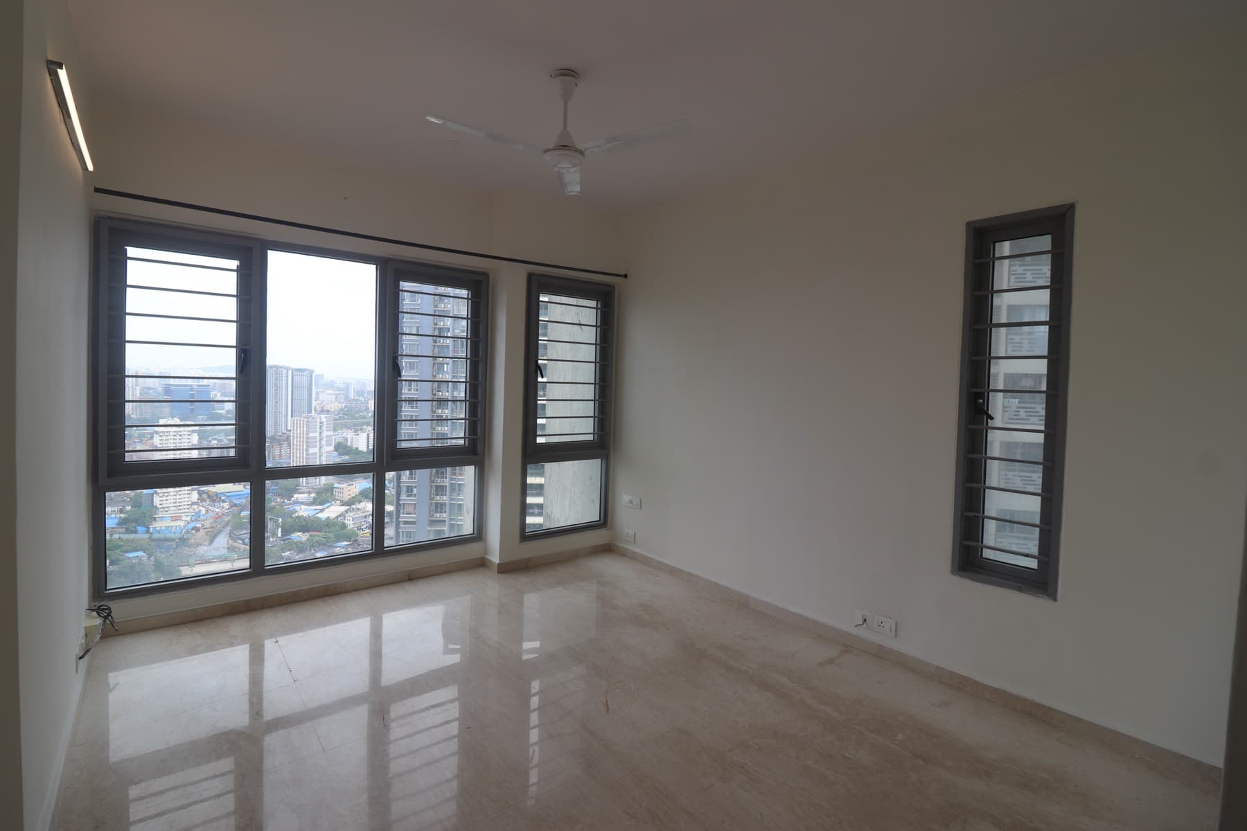 Empty bedroom on a high floor of Imperial Heights, Goregaon West, with marble flooring and a west-facing city view