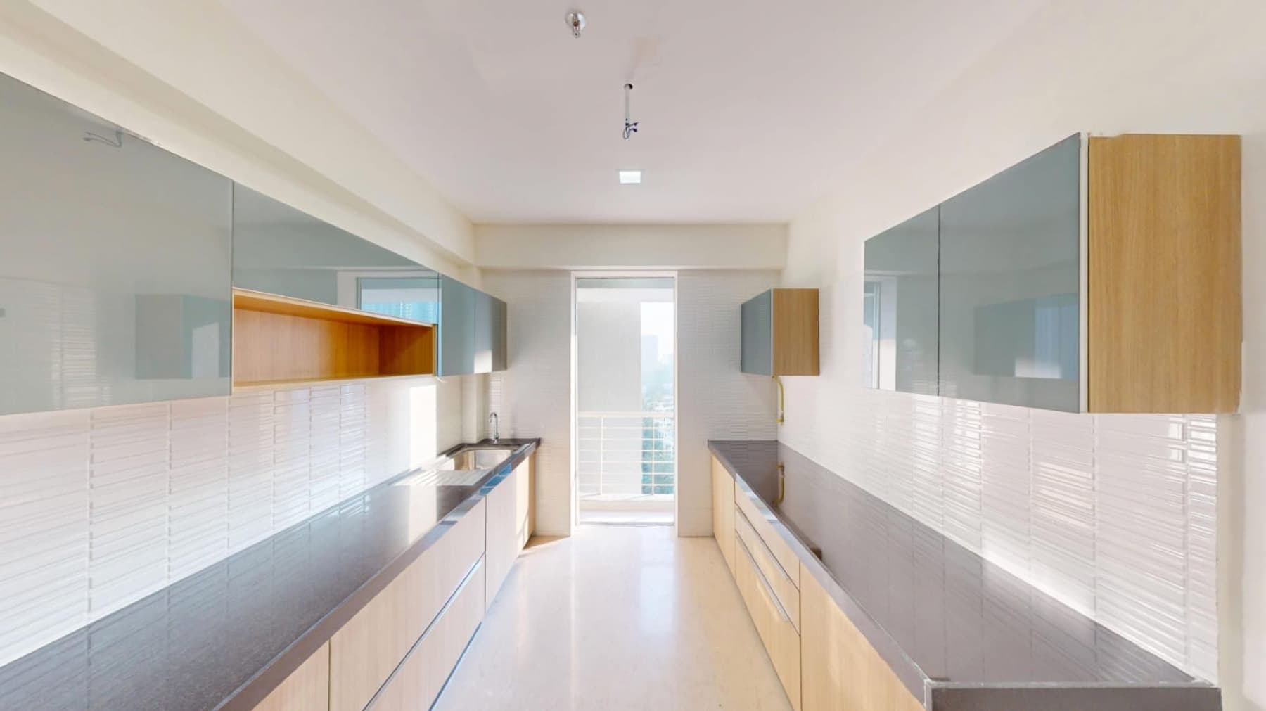 Kitchen of an empty 3 BHK at Ekta Tripolis, Goregaon West, opening onto a balcony